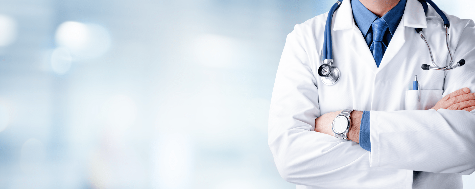 A doctor in a white lab coat with a stethoscope around his neck stands with arms folded for control de accesos para instituciones sanitarias.